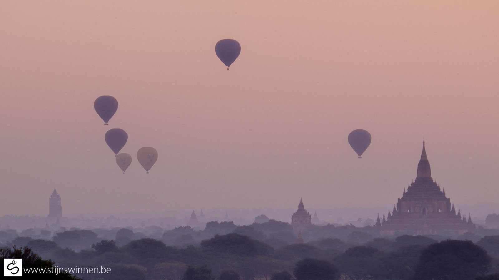 Pagoda in Bagan at sunrise with many balloons