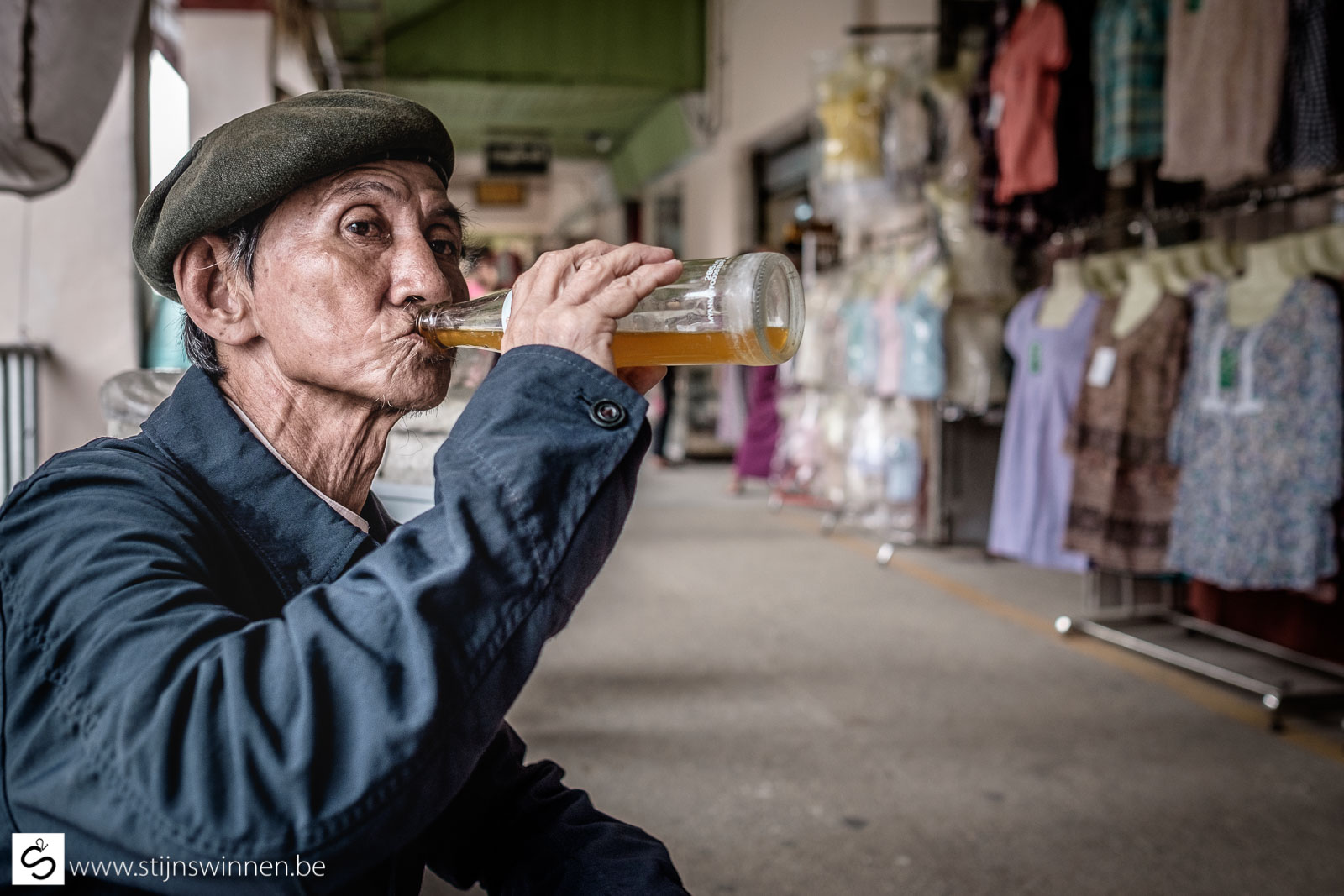 Old Burmese man drinking a soft drink on market in Yangon