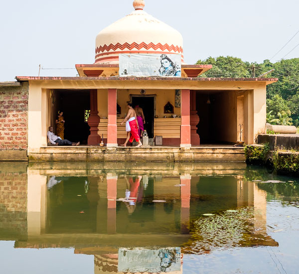 Small temple next to water in Goa