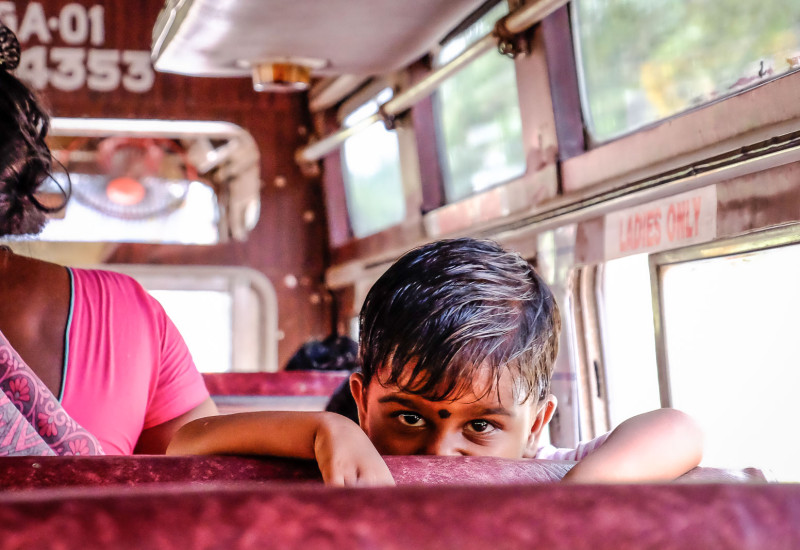 Little Indian boy staring on bus